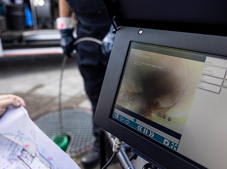 Kameraüberwachung bei Rohrinspektion Monitor zeigt Livebild einer Kamerainspektion im Rohr, technisches Equipment im Hintergrund sichtbar.