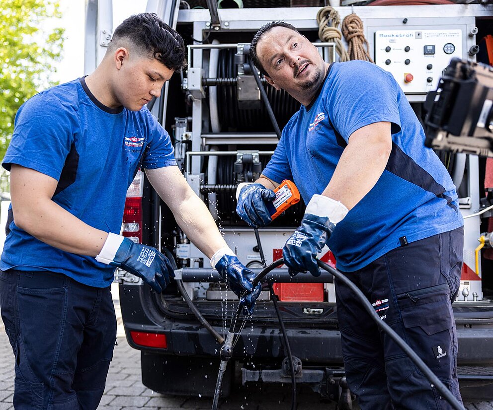 Einweisung Azubi bei Rohrreinigung PAKO-Mitarbeiter weisen einen Auszubildenden bei der Reinigung mit Einspülkamera und Wasserhochdruck ein.