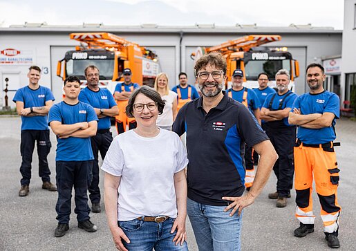 Teamfoto mit Fhrungskräften PAKO-Mitarbeiter und Führungskräfte stehen gemeinsam auf dem Hof und lächeln.
