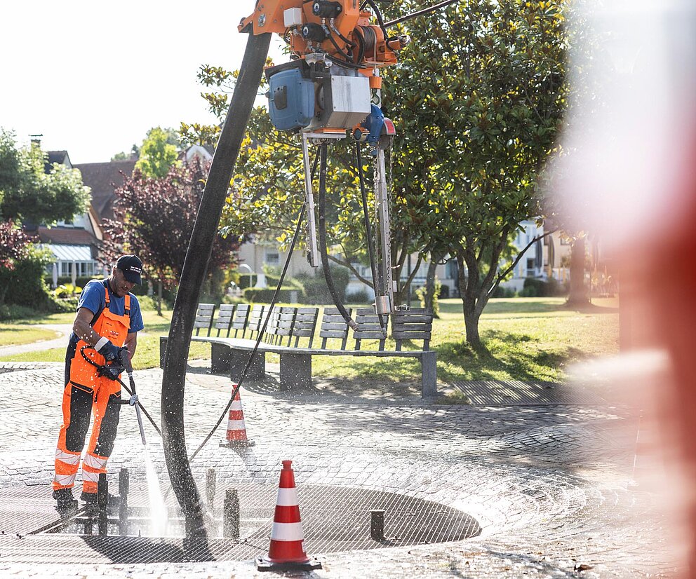 Spülarbeiten mit Hochdruck PAKO-Mitarbeiter führt Spülarbeiten mit Wasserhochdruck auf einer Baustelle durch.