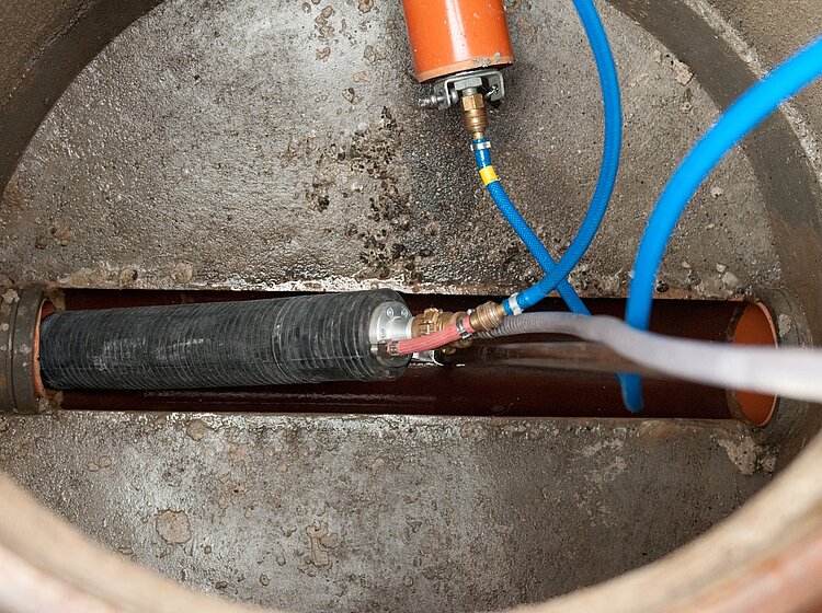 Dichtheitsprüfung im Kanalschacht Dichtheitsprüfung in einem Kanalschacht mit Druckmessgerät und angeschlossenen Schläuchen